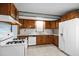Bright kitchen featuring wooden cabinets and a white refrigerator and stove at 7595 Clayton Blvd # B, Clayton, NC 27520