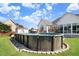 Backyard with a wooden fenced above ground pool in a well-maintained lawn at 8101 Claybrooke Ct, Willow Springs, NC 27592