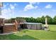 Backyard with a wooden deck leading to an above ground pool and a lush green lawn at 8101 Claybrooke Ct, Willow Springs, NC 27592