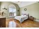 Inviting bedroom featuring hardwood floors, a vaulted ceiling, and a large arched window at 8101 Claybrooke Ct, Willow Springs, NC 27592