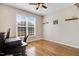 Bedroom with wood floors, a ceiling fan, large window, and wood shelves on the wall at 8101 Claybrooke Ct, Willow Springs, NC 27592