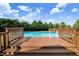 Backyard view of a private pool with a wooden deck and steps at 8101 Claybrooke Ct, Willow Springs, NC 27592