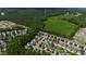 Aerial view showcasing a residential neighborhood near a green field and wooded area at 8205 Rolling Glenn Dr, Raleigh, NC 27616