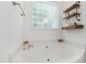 Modern bathroom with a soaking tub, wooden shelves and a large window for natural light at 8205 Rolling Glenn Dr, Raleigh, NC 27616