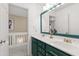 Stylish bathroom with double vanity, green cabinets, gold fixtures, and unique green framed mirror at 8205 Rolling Glenn Dr, Raleigh, NC 27616