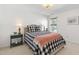 Cozy bedroom with a black and white checkered bedspread, side tables and carpeted flooring at 8205 Rolling Glenn Dr, Raleigh, NC 27616