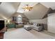 Spacious bonus room featuring comfortable seating, soft carpet, and a ceiling fan at 8205 Rolling Glenn Dr, Raleigh, NC 27616