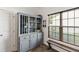 Dining area featuring a gray wine cabinet, a bench, and a window with natural light at 8205 Rolling Glenn Dr, Raleigh, NC 27616