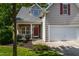 Charming home featuring a two-car garage, stone porch accents, and well-maintained landscaping at 8205 Rolling Glenn Dr, Raleigh, NC 27616