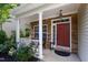 Inviting front porch with stone accents, white columns, and a cozy seating area at 8205 Rolling Glenn Dr, Raleigh, NC 27616