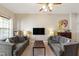 Inviting living room features neutral walls, two grey sofas, and a ceiling fan with bright lighting at 8205 Rolling Glenn Dr, Raleigh, NC 27616