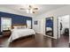 Spacious bedroom featuring a ceiling fan, dark wood flooring, and walk-in closet access for ample storage at 8205 Rolling Glenn Dr, Raleigh, NC 27616