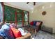Comfortable screened porch with wicker furniture, vibrant pillows, and views of the green backyard at 8205 Rolling Glenn Dr, Raleigh, NC 27616