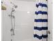 Clean shower with blue and white striped curtain, and a shower head with hand-held sprayer at 8205 Rolling Glenn Dr, Raleigh, NC 27616