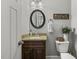 Bathroom with a granite vanity, a decorative mirror, and a toilet with decorative sign at 860 Cokesbury Rd, Fuquay Varina, NC 27526