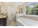 Bathroom featuring a soaking tub, window, tiled floor, and a granite countertop vanity at 860 Cokesbury Rd, Fuquay Varina, NC 27526