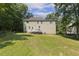 Spacious backyard with lush green grass and the exterior of the home and back deck in view at 860 Cokesbury Rd, Fuquay Varina, NC 27526