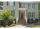 Close up of a charming home featuring a brick stairway leading to a bright red front door and blue shutters at 860 Cokesbury Rd, Fuquay Varina, NC 27526