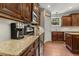 Well-lit kitchen with granite countertops, dark wood cabinets, and stainless steel appliances at 860 Cokesbury Rd, Fuquay Varina, NC 27526