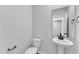 Half bathroom featuring modern fixtures, a pedestal sink, and a sleek mirror, enhancing a contemporary design at 1012 Rhino Bnd, Oxford, NC 27565