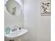 Powder room featuring a pedestal sink, a round mirror, and minimalist decor for a clean aesthetic at 102 Duxbury Dr, Cary, NC 27513