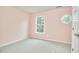 A bedroom with pink walls, gray carpet, and round window at 102 Duxbury Dr, Cary, NC 27513