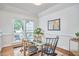 Well-lit dining room with glass table, modern decor, and views of the outdoor scenery at 102 Duxbury Dr, Cary, NC 27513