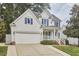 Charming two-story home featuring a two-car garage, blue shutters, and manicured landscaping at 102 Duxbury Dr, Cary, NC 27513