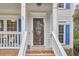Elegant front door with decorative glass, flanked by windows and a cozy porch seating area at 102 Duxbury Dr, Cary, NC 27513