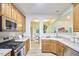 Well-lit kitchen boasts stainless steel appliances, wooden cabinetry, and seamless access to a connected dining area at 102 Duxbury Dr, Cary, NC 27513
