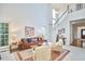 Bright and airy living room features vaulted ceilings, fireplace, and staircase at 102 Duxbury Dr, Cary, NC 27513