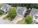 Aerial view of the home, featuring a large driveway and a wooded backyard with fire pit at 1144 Dexter Ridge Dr, Holly Springs, NC 27540