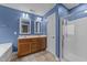 Bright bathroom with double sinks, wood cabinets, and tiled flooring, next to glass shower at 1144 Dexter Ridge Dr, Holly Springs, NC 27540