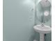 Half bathroom with pedestal sink and a modern round mirror at 1144 Dexter Ridge Dr, Holly Springs, NC 27540