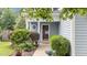 Inviting home entrance with a well-kept landscape, covered porch, and glass paneled door at 1144 Dexter Ridge Dr, Holly Springs, NC 27540