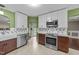 Updated kitchen features stainless appliances, farmhouse sink, and stylish countertops and backsplash at 1144 Dexter Ridge Dr, Holly Springs, NC 27540