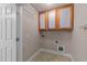 Convenient laundry room with overhead storage and tile flooring at 1144 Dexter Ridge Dr, Holly Springs, NC 27540