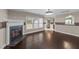 Bright and spacious living room with a fireplace, dark wood floors, and large windows at 1144 Dexter Ridge Dr, Holly Springs, NC 27540