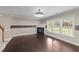 Spacious living room with a fireplace, gleaming hardwood floors and large windows at 1144 Dexter Ridge Dr, Holly Springs, NC 27540