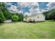 Expansive backyard with lush lawn, showcasing the home's exterior and surrounding greenery at 125 Green Ln, Clayton, NC 27520