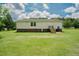 Spacious backyard featuring a well-maintained lawn, a two-story house, and mature trees at 125 Green Ln, Clayton, NC 27520