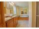 Bathroom featuring double sinks, jacuzzi tub, wood cabinets, and decorative mirrors at 125 Green Ln, Clayton, NC 27520