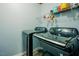 Modern laundry room featuring a black washer and dryer set, with shelving for storage at 125 Green Ln, Clayton, NC 27520