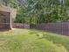 This large backyard has a dark fence and mature trees at 128 Chapel Run Way, Chapel Hill, NC 27517