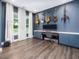 Stylish room with wall-mounted guitars, a keyboard, modern lighting, large window, and dark wood floors at 128 Chapel Run Way, Chapel Hill, NC 27517