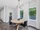 Cozy dining room features a modern chandelier, natural light, dark wood floors, and modern furniture at 128 Chapel Run Way, Chapel Hill, NC 27517