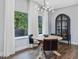 Bright dining room with large windows, modern chandelier, dark wood floors and modern furniture at 128 Chapel Run Way, Chapel Hill, NC 27517
