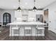 Modern kitchen featuring stainless steel appliances, a large island with seating, and elegant pendant lighting at 128 Chapel Run Way, Chapel Hill, NC 27517