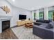 Cozy living room with fireplace, decorative wall art, and comfortable sectional sofa, perfect for relaxation at 128 Chapel Run Way, Chapel Hill, NC 27517