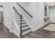 Modern staircase with dark wood treads, white risers, and a dark wood handrail at 128 Chapel Run Way, Chapel Hill, NC 27517